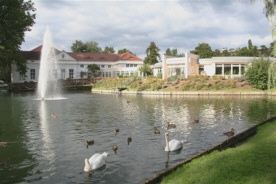 Blick über einen Teil des Schwanenteichs auf das Therapiezentrum im Kurpark