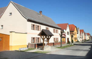 Blick auf die Dorfstraße mit wiedererrichteten Brunnen