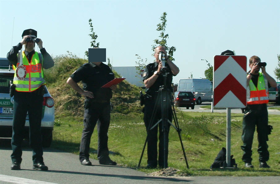 Polizisten mit Ferngläsern und Laser Traffipatrol